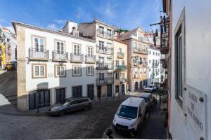 eine Stadtstraße mit Autos, die vor den Gebäuden geparkt sind in der Unterkunft FLH Mouraria Charming Flat II in Lissabon