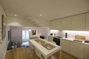 a kitchen with white cabinets and a table and a counter at FLH Porto Spacious Duplex in Porto