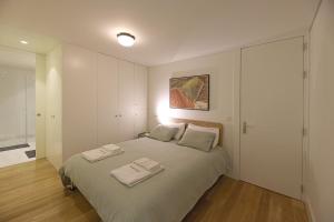 a bedroom with a bed with two towels on it at FLH Porto Spacious Duplex in Porto