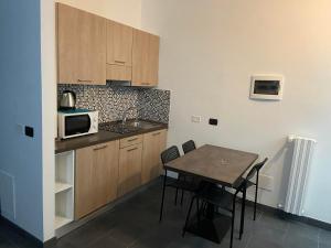 a small kitchen with a table and a microwave at BICOCCA APPARTAMENTI in Milan
