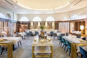 un comedor con mesas y sillas blancas en Fraser Suites Hamburg, en Hamburgo