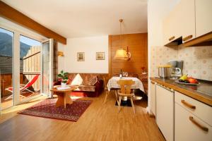 a kitchen and a living room with a table at Alpina Residence in Naturno