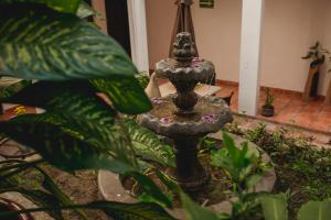 a stone fountain in a garden with plants at Posada Kin in Palenque