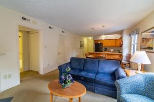 a living room with a blue couch and a table at Massanutten Resort by TripForth in McGaheysville