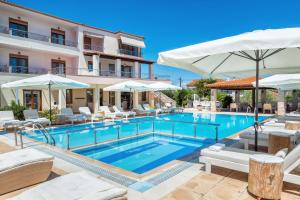 a pool at a hotel with chairs and umbrellas at Hesperides Hotel Pefkochori in Pefkochori