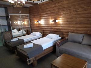 a room with two beds and a couch and a mirror at Zatyshok in Svalyava