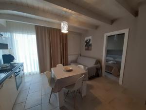 une cuisine et un salon avec une table et une chambre dans l'établissement Dimora Girolamo, à Polignano a Mare