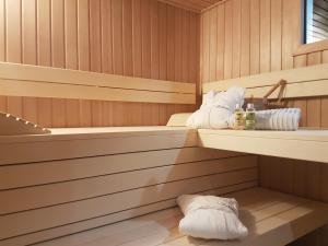 - un sauna avec des serviettes et des bouteilles sur les étagères dans l'établissement Belamor, à Sankt Michael im Lungau