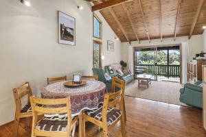 a dining room with a table and chairs and a living room at 112 Mooloomba Road in Point Lookout