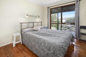 een slaapkamer met een bed en een groot raam bij Eyrie in Point Lookout