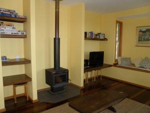 un soggiorno con una stufa a legna di 11 Bambara Street a Point Lookout
