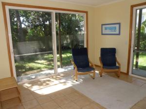 un soggiorno con due sedie e una grande finestra di 11 Bambara Street a Point Lookout