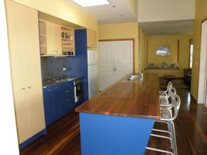 una cucina con armadi blu e ripiano in legno di 11 Bambara Street a Point Lookout
