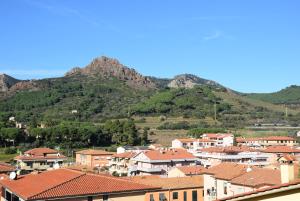 a town with houses and mountains in the background at Sogno Azzurro - ArgonautiVacanze in Porto Azzurro