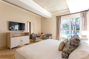 une chambre avec un lit, une télévision et une fenêtre dans l'établissement Eurostars Marqués de Villalta, à Carthagène des Indes