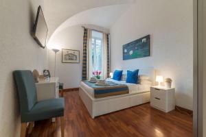 a bedroom with a bed with blue pillows and a chair at CS Piazza Venezia Apartment in Rome