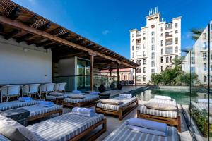 a patio with chaise lounge chairs and a swimming pool at Eurostars Marqués de Villalta in Cartagena de Indias