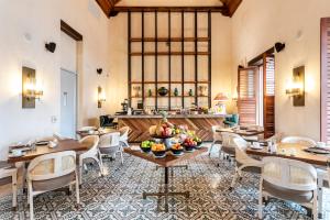un restaurant avec des tables et des chaises dans une salle dans l'établissement Eurostars Marqués de Villalta, à Carthagène des Indes