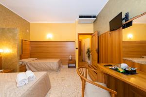 a hotel room with two beds and a desk at La Lanterna in Silvi Marina