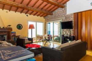 Sala de estar con sofás, TV y mesa en Villa Glaucos, en Capoliveri