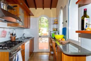 a kitchen with wooden cabinets and a counter top at Villa Glaucos in Capoliveri