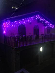 GarzenoChalet con Piscina的旁边是紫色灯的房子