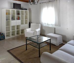 a living room with a glass coffee table and chairs at Casa Las Viñas in Fuentidueña