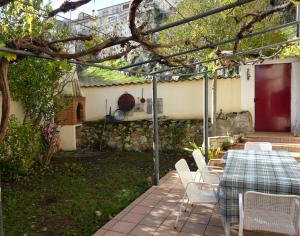een patio met een tafel en stoelen in een tuin bij Casa Las Viñas in Fuentidueña