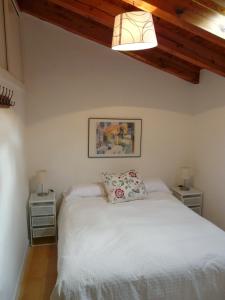 1 dormitorio con 1 cama blanca y 2 mesitas de noche en Casa Las Viñas, en Fuentidueña