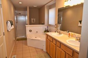 a bathroom with a tub and two sinks and a shower at The Lodge at Old Kinderhook in Camdenton