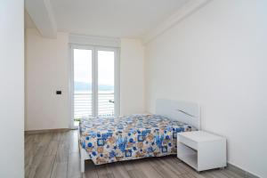 una camera bianca con un letto e una finestra di Appartamento Fronte Mare a Portoferraio