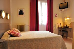 a bedroom with a bed with red curtains and a window at Hotel Lux in Grenoble