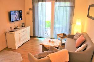 a living room with a couch and a tv at Ferienwohnungen Haus Inselblick mi in Göhren
