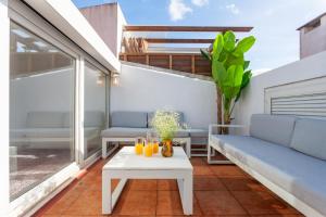 uma pequena varanda com uma mesa branca e bancos em Liberty Penthouse Three-Bedroom Apartment - by LU Holidays em Lisboa
