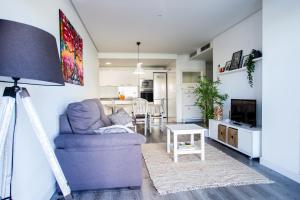 ein Wohnzimmer mit einem Sofa und einem Tisch in der Unterkunft Apartamento nuevo en la playa- MET- Oliva Nova Golf in Oliva