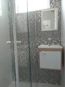 y baño con ducha, lavabo y espejo. en Rigs Hotel, en São José dos Campos