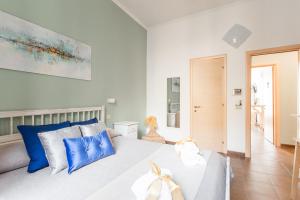 a bedroom with a large bed with blue pillows at Domus Victoria Guest House in Rome