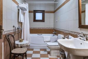 La salle de bains est pourvue d'une baignoire, de toilettes et d'un lavabo. dans l'établissement Margit Suites Hotel, à Karpenísi