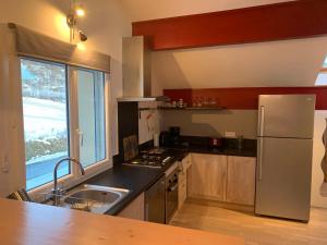 a kitchen with a stainless steel refrigerator and a sink at loft sur les montagnes in Saint-Michel-de-Chaillol