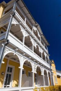 ein gelbes Haus mit weißem Schnitt in der Unterkunft Haus Sonne in Ostseebad Sellin