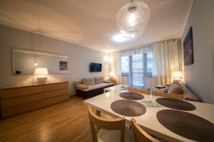 a living room with a dining table and a couch at Wyspa Uznam - Apartamenty Zdrojowa in Świnoujście