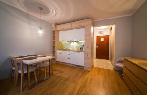 a kitchen and dining room with a table and chairs at Wyspa Uznam - Apartamenty Zdrojowa in Świnoujście