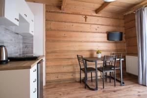 ein Esszimmer mit Holzwänden und einem Tisch mit Stühlen in der Unterkunft Apartamenty "Pod Tatrami" in Zakopane