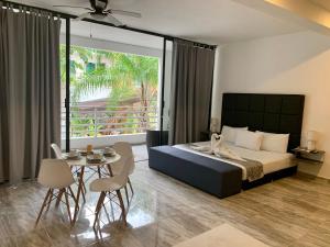 1 dormitorio con 1 cama y 1 mesa con sillas en SILVERSANDS Hotel Boutique - 5Th Ave en Playa del Carmen