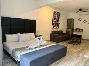 a bedroom with a bed with two swans on it at SILVERSANDS Hotel Boutique - 5Th Ave in Playa del Carmen