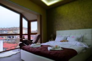 ein Schlafzimmer mit einem Bett mit Handtüchern darauf in der Unterkunft Версай in Kasanlak