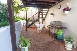 an outdoor patio with a table and a grill at 12 On Oyster in Durban