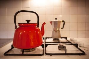 a red tea kettle sitting on top of a stove at Residence Menotre in Rasiglia