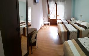 A bed or beds in a room at Hostal Campoamor