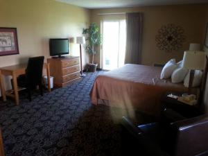 a hotel room with a bed and a desk and a television at Pine View Resort in Monticello